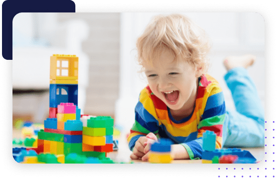 A child happily engages with toy blocks, developing cognitive and motor skills through play.